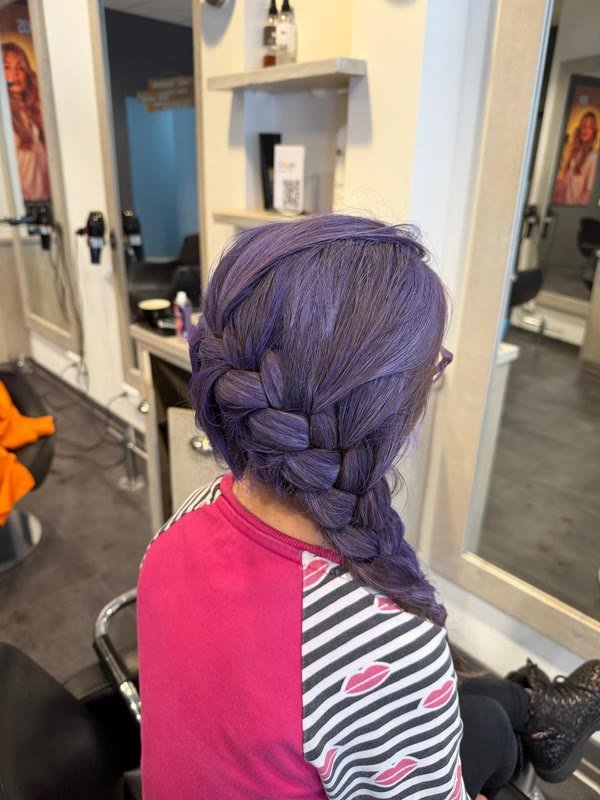 Paarse vlecht in kinderhaar, gevlochten in de salon